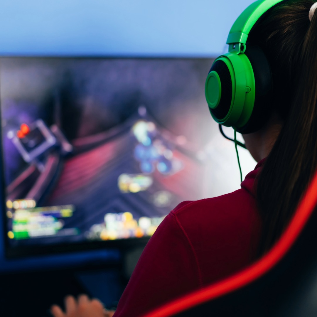 A player wearing green headphones at a gaming setup.